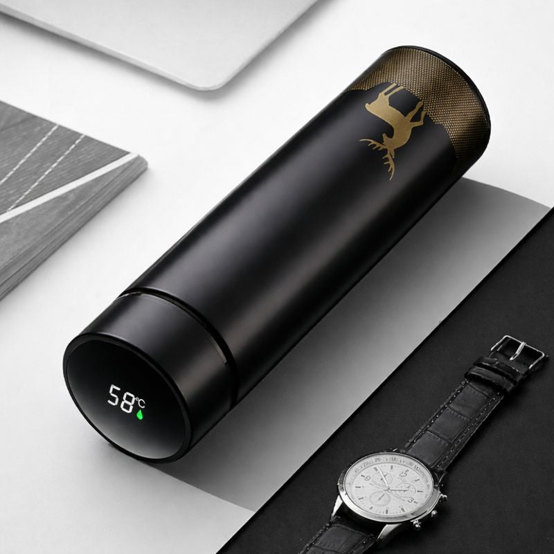 Black thermos with digital temperature display next to a watch on a light gray surface