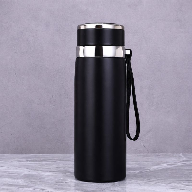 Black insulated bottle with silver lid on a gray background