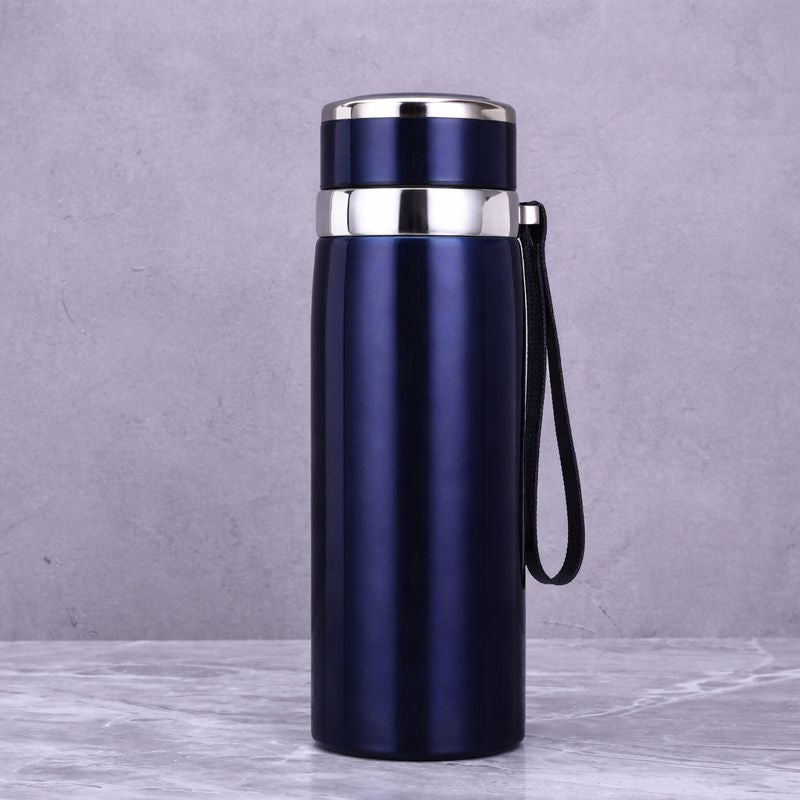 Blue insulated bottle with silver lid on a gray background