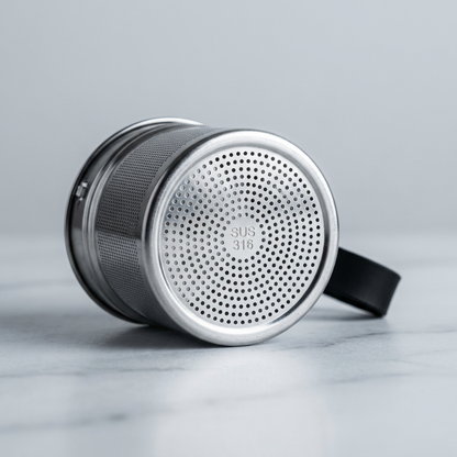 Metal strainer with perforated design on a gray background