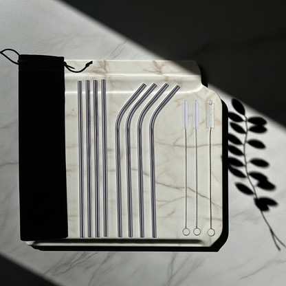 Set of reusable straws in a clear plastic case on a marble surface