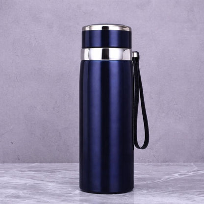 Blue insulated bottle with silver lid on a gray background